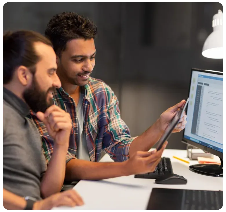 Two developers reviewing an application on a monitor