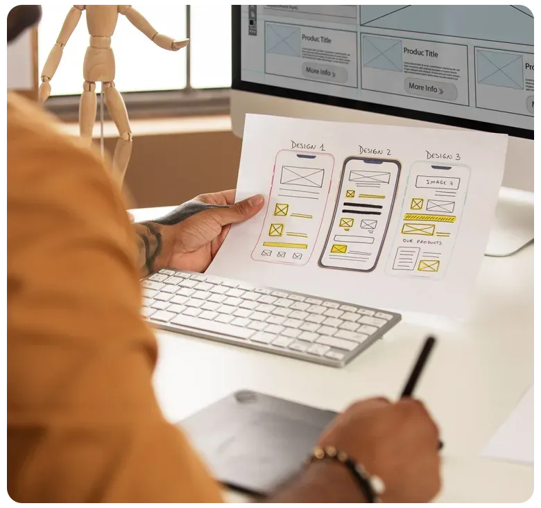 Mobile app wireframes being reviewed at a desk
